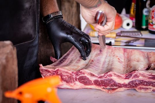 carnicero cortando costilla de res